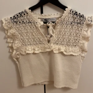 Vit stickad topp från Zara - Säljer en söt vit stickad topp från Zara med spetsdetaljer. Helt oanvänd med lappen kvar, nypris 359kr. Skriv vid frågor eller för fler bilder🥰