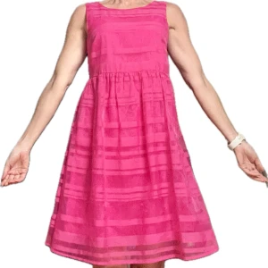 Rosa ärmlös klänning - Snygg rosa klänning med ett randigt mönster. Den är ärmlös och har en luftig passform som passar perfekt för varma dagar. Klänningen har en rund halsringning och når till knäna.