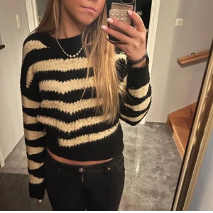 Svart och beige randig tröja - Säljer en mysig svart och beige randig tröja med lång ärm. Tröjan har är lite croppad. Den är nopprig men fin ändå 