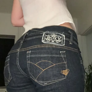Mörkblå jeans från Roxy - Snygga mörkblå jeans från Roxy med kontrasterande sömmar och klassisk femficksdesign. Jeansen har en låg midja och en tight passform som framhäver figuren. Perfekta för en avslappnad stil. Skulle säga att dom sitter mellan en 36/38 och jag är runt 170 cm lång