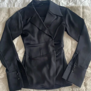 Kavaj i satin från Gina tricot - En Kavaj med knappar i midjan för att få en ⌛️ look. Knappar på ärmarna och materialet på kavajen är satin. Passar för både utekvällar och när det är dags att vara seriös på ett kontorsmöte eller jobbintervju!