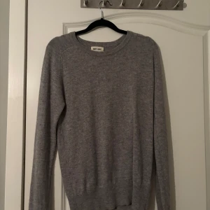 Grå kashmirtröja från Soft Goat - Säljer en supermjuk och stilren grå kashmirtröja från Soft Goat. Perfekt för kyliga dagar med sin klassiska design och långa ärmar. Tröjan har en rund halsringning och ribbade kanter som ger en snygg passform. Ett måste i garderoben för den som älskar komfort och stil. 🐐✨
