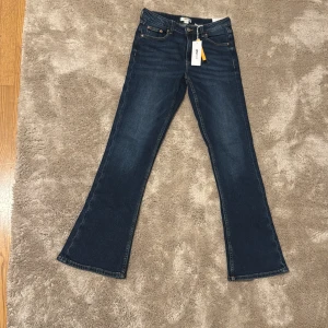 Blå bootcut jeans från Gina Tricot - Snygga mörkblå bootcut jeans från Gina Tricot med lappen kvar, aldrig använda bara testade🥰 Storlek 164 men stora i storleken. Nya kostar 299kr❣️
