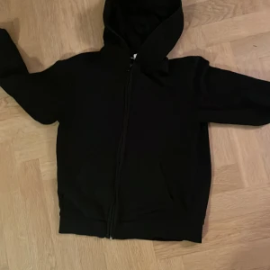 Svart hoodie med dragkedja - Säljer en klassisk svart hoodie med dragkedja och huva. Perfekt för en avslappnad stil. Den har långa ärmar och en bekväm passform. Passar bra till både jeans och mjukisbyxor. 🖤