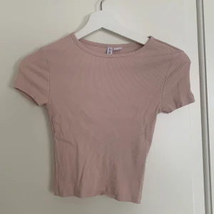 Rosa ribbad topp  - Säljer en söt rosa ribbad topp från H&M. Den har en enkel design med korta ärmar och en rund halsringning. 