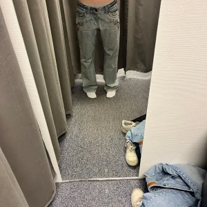 Coola vintage lowwaist jeans - Snygga blå jeans med unika pärldetaljer på fickorna. De har en lågmidjad passform och en baggy stil. Ascool färg med snygga detaljer! Vet inte märket. Storlek M men passar snyggt lite baggy på S