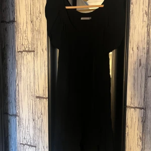 Svart klänning från Å - Snygg svart klänning från Å i storlek S. Den har en enkel och elegant design med korta ärmar och en rund halsringning. Perfekt för en stilren look.