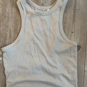 Beige ribbad linnetopp - Säljer en stilren vit ribbad linnetopp. Mycket sparsamt använd. Från H&M. Skönt material!