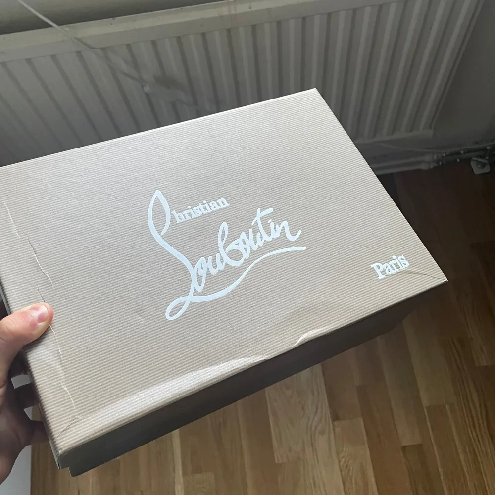 Snygga svarta sneakers i mocka med en ikonisk röd sula. Skorna har snörning och en stilren design som passar perfekt för en trendig look.. Kengät.