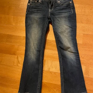 Blåa bootcut jeans ifrån Miss me - Super snygga bootcut jeans ifrån miss me. Endast använd en gång. Inga defekter. Storlek W30. Midjemått 42,5 cm. Innerbenslängd 76cm.