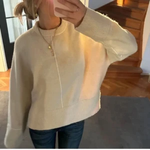 Vit stickad tröja - Säljer en mysig vit stickad tröja med normal passform. Tröjan är  nopprig  men inget som syns mycket. Lånade bilder så skriv om egna!