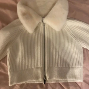 Vit jacka från Zara - Säljer en stilren vit jacka från Zara med dragkedja och mjuk krage. Jackan har en ribbad textur och är perfekt för kyligare dagar. Den är långärmad och har en snygg, modern design.