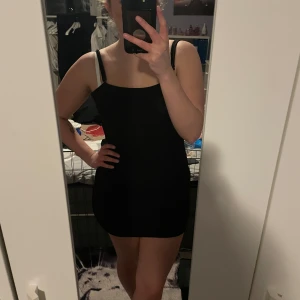 Svart tight glittrig klänning - Säljer nu denna fina klänningen som passar perfekt till nyår då den är glittrig. Den är lite längre men går enkelt att vika upp så den bli kortare om man vill det. Endast använd ett fåtal gånger så den är i fint skick💞