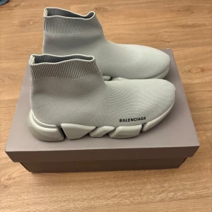 Balenciaga skor - Snygga grå sneakers från Balenciaga med en modern och stilren design. Skorna har en strumpliknande passform och en chunky sula som ger extra komfort. Perfekta för en trendig look.