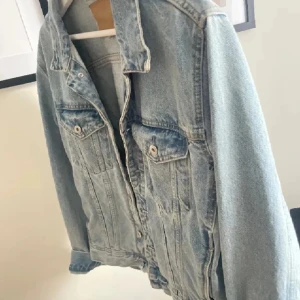 Ljusblå jeansjacka - Snygg ljusblå jeansjacka med klassisk design och knappar framtill. Perfekt för lager-på-lager stil och passar till många olika outfits.