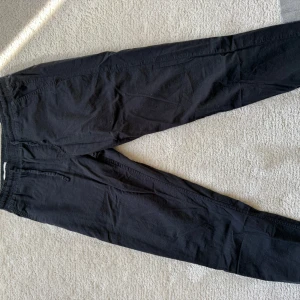 Svarta linnebyxor från Jack & Jones - Säljer ett par svarta linnebyxor från Jack & Jones. Byxorna har en relaxed passform med elastisk midja och dragsko. Perfekta för en avslappnad stil.