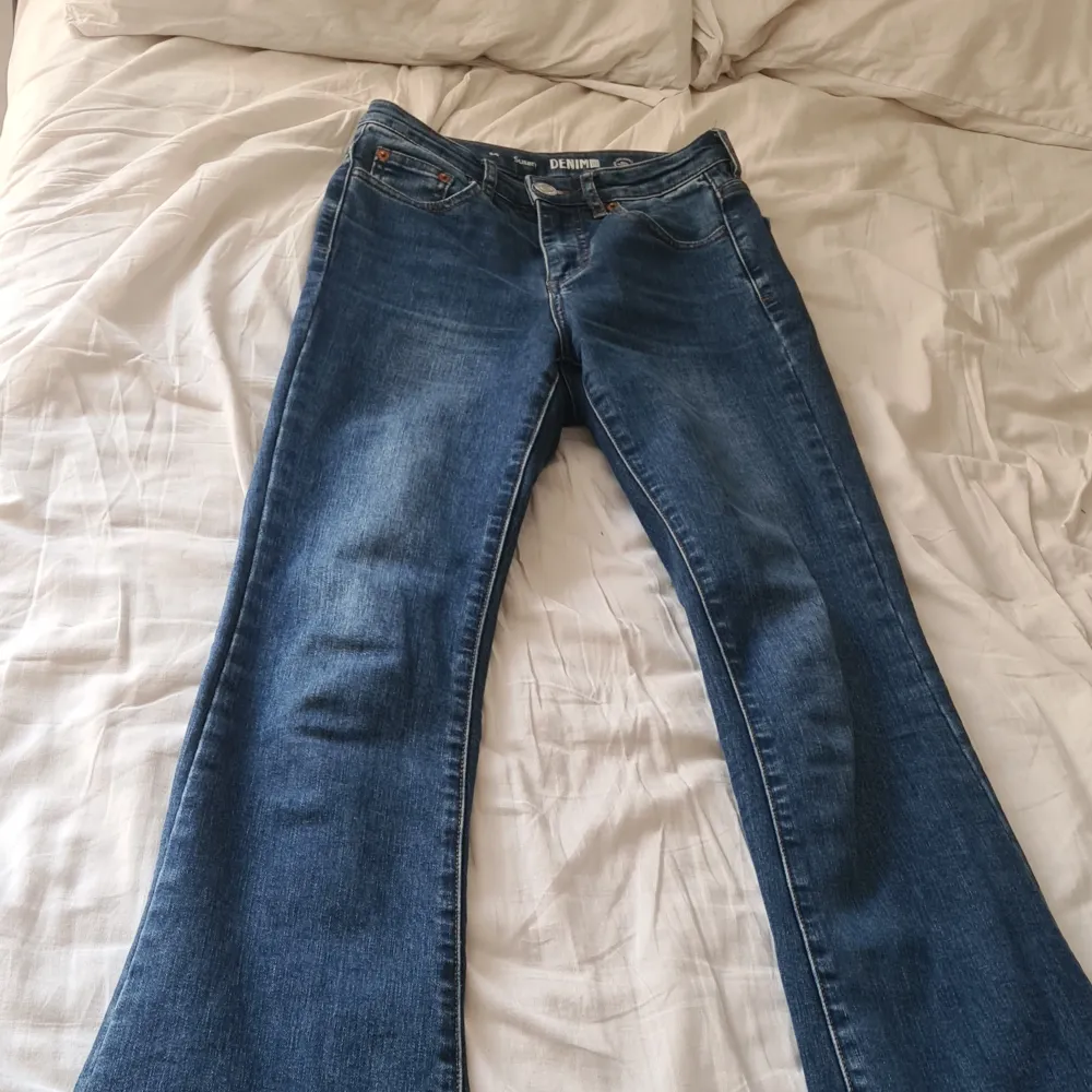 Säljer ett par klassiska blå bootcut jeans midwasit. Jeansen har fem fickor, dragkedja och knapp framtill. Perfekta för dig som gillar en tidlös stil med lite utsvängda ben. Sälj för kmr it till användning💕. Farkut & Housut.