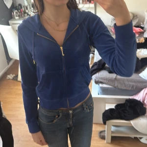 Blå velour juicy jacka - Säljer en snygg blå velour hoodie från Juicy Couture. Den har en dragkedja framtill och en praktisk huva med snörning. Perfekt för en avslappnad stil. 💙