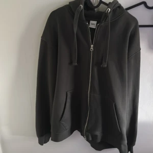 Grå hoodie från Zara - Säljer en grå hoodie från Zara med dragkedja och luva. I princip nyskick då den endast använd fåtal gånger och är tvättad en gång. Nypris 600kr, mitt pris 300kr. Tveka inte o höra av dig vid frågor.