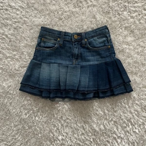 Jeanskjol med volang - Lågmidjad jeanskjol omsydd från ett par jeans. Midjemått tvärsöver- 31cm Längd- 31cm Har inga bilder på då den är för liten.
