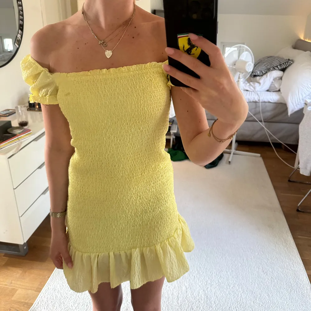 Söt ljusgul kortklänning från Zara med offshoulder och puffärmar. Klänningen har smockad överdel och en volang längst ner. . Mekot.