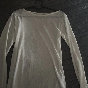 Vit långärmad topp från Nelly - Säljer en enkel och stilren vit långärmad topp från Nelly. Toppen har rund halsringning och är tillverkad i ett mjukt material som passar perfekt till många olika outfits. Den är i stl XL men sitter som en S 