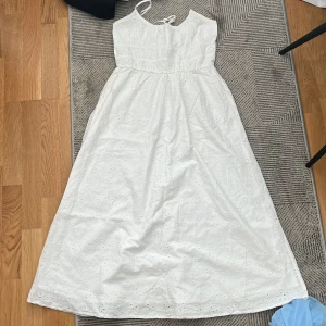 Vit långklänning med broderad detalj - Säljer en vacker vit långklänning med broderade detaljer och smala axelband. Perfekt för sommarens alla tillfällen. Klänningen har en luftig passform och en romantisk känsla. Kontakta mig för mer info! 🌸
