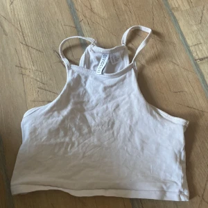 Vit croppad linnetopp från H&M Divided - Säljer en vit croppad linnetopp från H&M Divided. Toppen har smala axelband och är perfekt för varma dagar. Enkel och stilren design som passar till mycket.