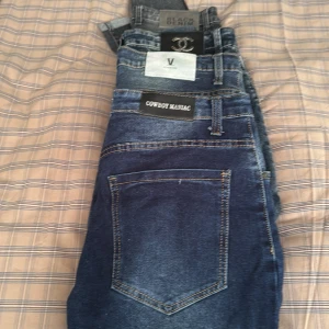 Blå jeans från Cowboy Maniac - Säljer 4 par snygga blå jeans från Cowboy Maniac. De har en klassisk femficksdesign och en mörkblå tvätt som ger en stilren look. Perfekta för en avslappnad stil.