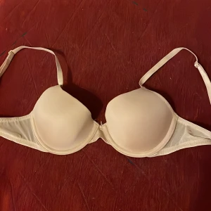 Beige bh från HM - Säljer en beige bh med mjukt tyg och justerbara axelband. Perfekt för en bekväm och diskret look, storlek 75A från HM.