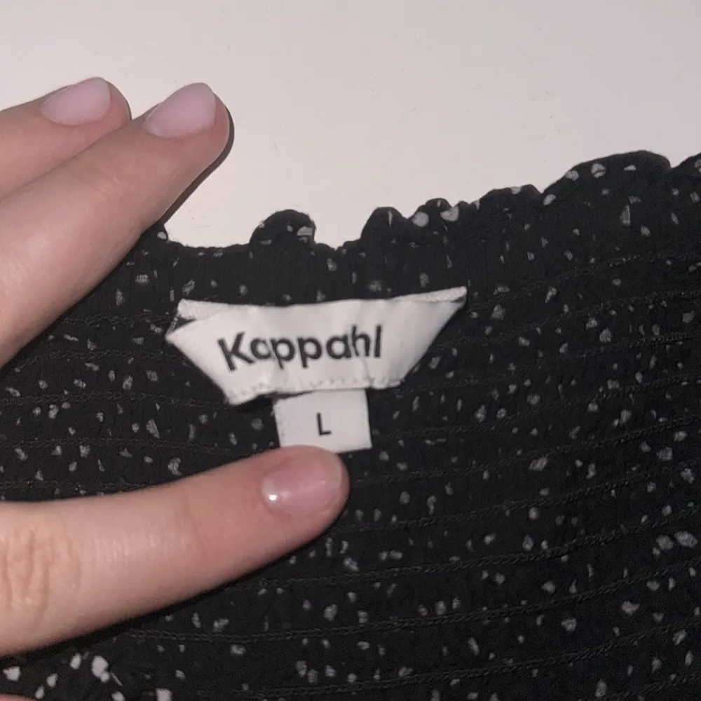 Säljer en svart kortkjol från Kappahl med vita prickar. Kjolen har en elastisk midja för en bekväm passform. Perfekt för en stilren look.. Hameet.