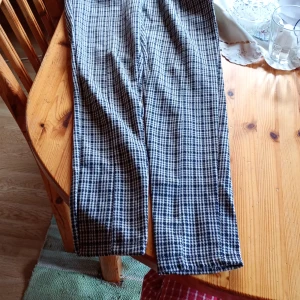 Rutmönstrade byxor i svart och vitt brunt stl  L - Snygga byxor med klassiskt rutigt mönster i svart och vitt. Brunt Byxorna har rak passform och normal midja, perfekta för en stilren look. Materialet känns mjukt och bekvämt mot huden.