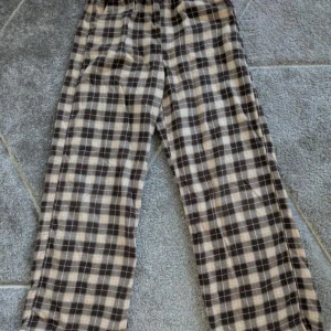 Rutiga byxor från H&M - Bekväma rutiga byxor från H&M i bruna och beige.Byxorna är vida i benen.