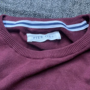 Vinröd tröja från Pier One - Säljer en stilren vinröd tröja från Pier One. Tröjan har långa ärmar och en rund halsringning. Perfekt för en avslappnad stil.