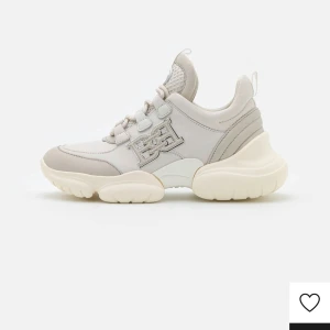Vita sneakers med chunky sula - Bally märkes skor, fins orginal låda och påse till, nästintill nyskick, enbart fåtal små märken runt sula och lite rynkor i lädret. Ordinarie pris 4500kr öppen för förslag på pris men snabb affär är viktigast. Säljer ett par vita sneakers med chunky, vågig sula och snörning. Skorna har en stilren design med detaljer i syntetmaterial och ett upphöjt märke på sidan. Perfekta för dig som gillar en modern och sportig look.