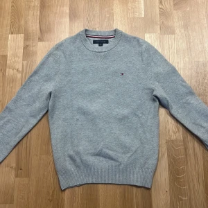 Tommy Hilfiger tröja som ny - Säljer fin Tommy Hilfiger tröja i grå färg. Använd en gång så den är som ny. Nypris 799kr.