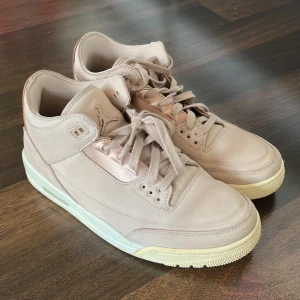 Beige/rosa  Nike Air Jordans - Säljer ett par stilrena beige Nike Air Jordans i skinn. Skorna har en klassisk design med snörning och rund tå. Perfekta för dig som vill ha en snygg och bekväm sneaker med ikonisk stil.