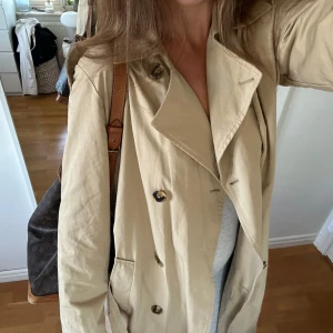 Snygg beige trenchcoat från Object - Så fin trench från Object! Knappt använd, men har en liten fläck framtill jag inte försökt få bort, se bilder. Superfin till våren, jag är 185 för längdreferens. Passar mig som är en M i vanliga fall. Så fin🤍