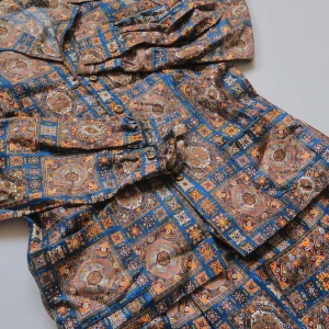 Retro mönstrad kavaj och kjolset - Unikt set med kavaj och kjol i retrostil, täckt av ett färgstarkt rutor-mönster i blått, brunt, beige och gult. Kavajen har klassisk krage, knappar framtill och långa ärmar. Kjolen är vid och matchar perfekt. Perfekt för dig som vill sticka ut med vintagevibbar.