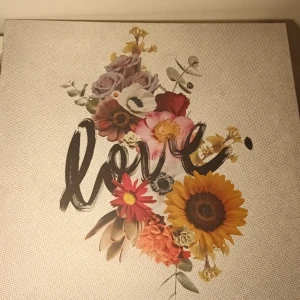Tavla - En vacker tavla med blommigt i mitten och ordet 'love' i konstnärlig stil. Perfekt för dig som gillar estetik, inspiration och vill ha något unikt på väggarna. Passar både som present och för egen  bredd 56cm längd 56,5