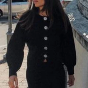 Svart kofta med rosformade knappar Zara - Svart kofta från Zara med rund halsringning och unika rosformade silverknappar framtill. Modellen är croppad med ballongärmar och breda muddar. Perfekt för dig som gillar stilrena plagg med en twist. Materialet är mjukt och stickat.