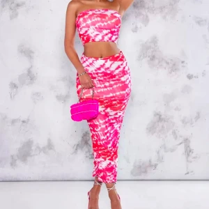 Rosa och vit tie-dye långklänning - Trendig långklänning i rosa och vitt tie-dye mönster. Klänningen är ärmlös och axelbandslös med en figurnära passform som framhäver midjan. Perfekt för dig som vill sticka ut med färg och mönster i sommar. KOMMER I SETT SÅ MAN FÅR TOPPEN OCKSÅ PÅ KÖPET