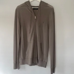 Beige merino hoodie från AllSaints - Säljer denna snygga beigea hoodie från AllSaints i 100% merinoull. Storlek S i nytt skick, aldrig använd. 