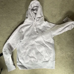 Ljusgrå hoodie från Russemerch - Snygg ljusgrå hoodie från Russemerch med klassisk känguruficka och huva med snörning. Mjuk insida och ribbade muddar. Perfekt för chill dagar eller när du vill ha en enkel och stilren look.