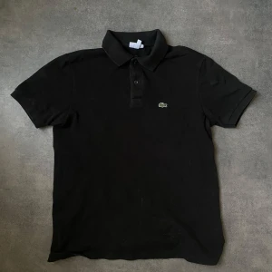 Svart pikétröja från Lacoste - Tja! Säljer nu min Svarta Lacoste Piké då den blev för liten.Den är i väldigt bra skick✅Perfekt för sommaren 💯 250kr och den är din👌 Tveka inte av att fråga👍