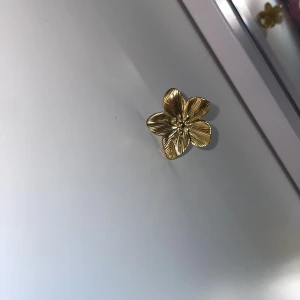 Guldig blomring med stor blomma - Statementring i guldtonad metall med en stor, detaljerad blomma som har fem blad och fina räfflade detaljer. Perfekt för dig som vill sticka ut och addera en cool touch till din look. Ringen är justerbar och passar de flesta storlekar. Den är från LYLA 