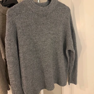 Grå stickad tröja från lager 157 - Mysig grå stickad tröja från lager 157 i storlek M. Perfekt för kyliga dagar med sin varma och bekväma design. Tröjan har en klassisk passform och långa ärmar! 🩶🩶
