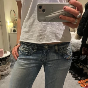 Diesel jeans - Snygga blå jeans med låg midja och klassisk femficksdesign. Jeansen har en straight passform och är perfekta för en avslappnad stil. De har en dragkedja och knapp framtill.