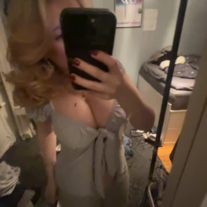 Grå knytblus, använd fåtal gånger  - Säljer en söt grå blus med knyt framtill. Blusen har korta ärmar och en v-ringad design som ger en feminin touch. Perfekt för en avslappnad stil.