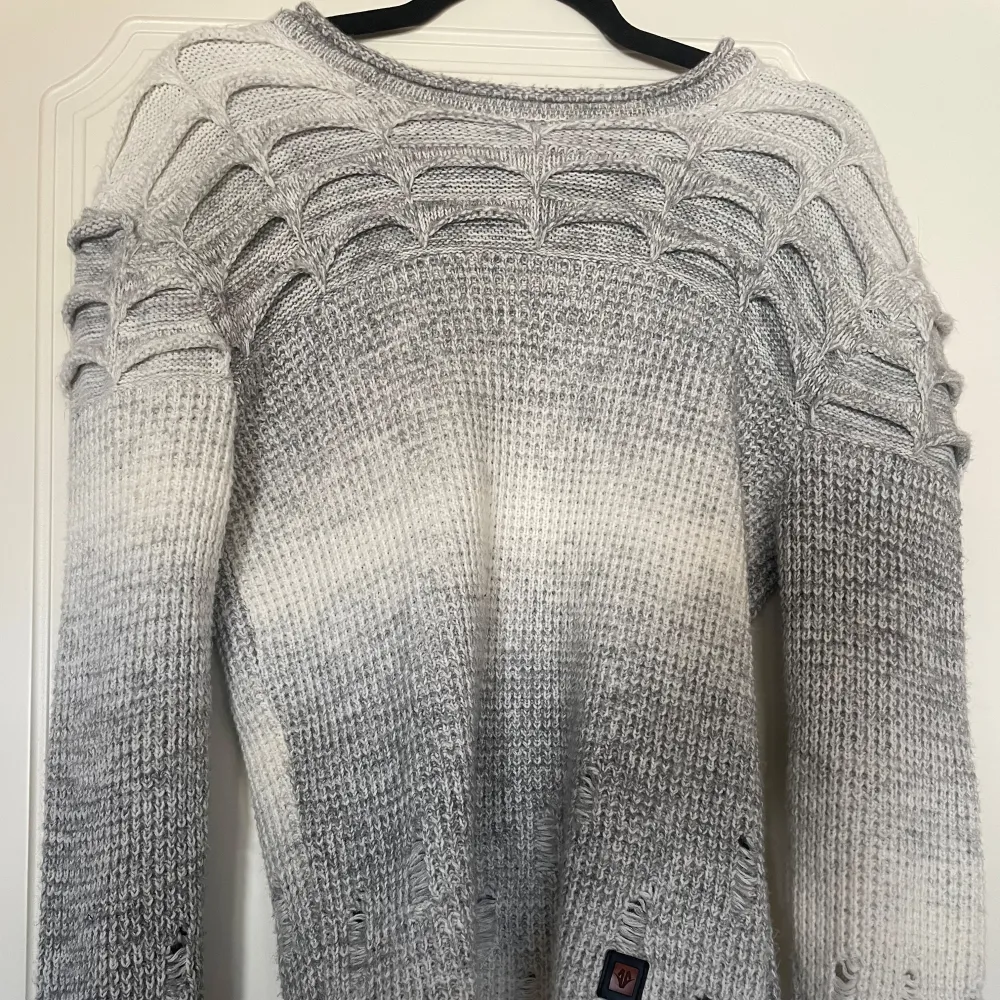 Snygg grå stickad tröja med unikt mönster på axlarna. Tröjan har en ombre-effekt från mörkare till ljusare grå och långa ärmar. Y2k/streetstyle. Skriv för att diskutera pris.. Neuletakit & Villapaidat.